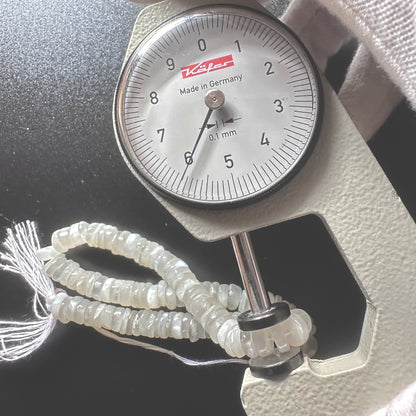 A dial gauge measures the Moonstone smooth wheel 6mm gemstone.