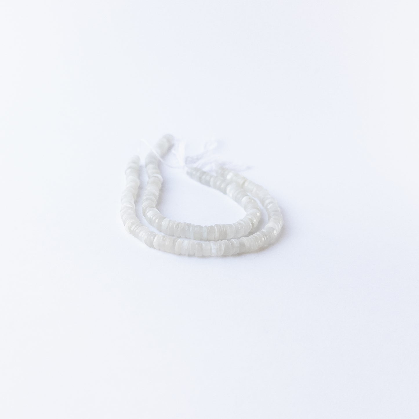 Moonstone smooth wheels displaying ethereal shimmer and premium craftsmanship in delicate beadwork.