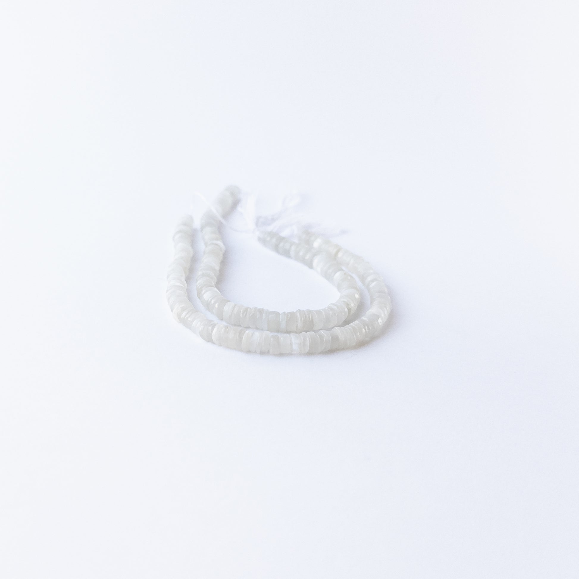 Moonstone smooth wheels displaying ethereal shimmer and premium craftsmanship in delicate beadwork.