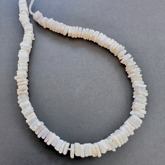 Close-up of Moonstone square heishi beads with luminous white tones and blue sheen.