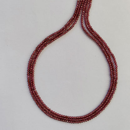 Detailed view of finely faceted Garnet rondelles aligned along a uniform 32cm strand.