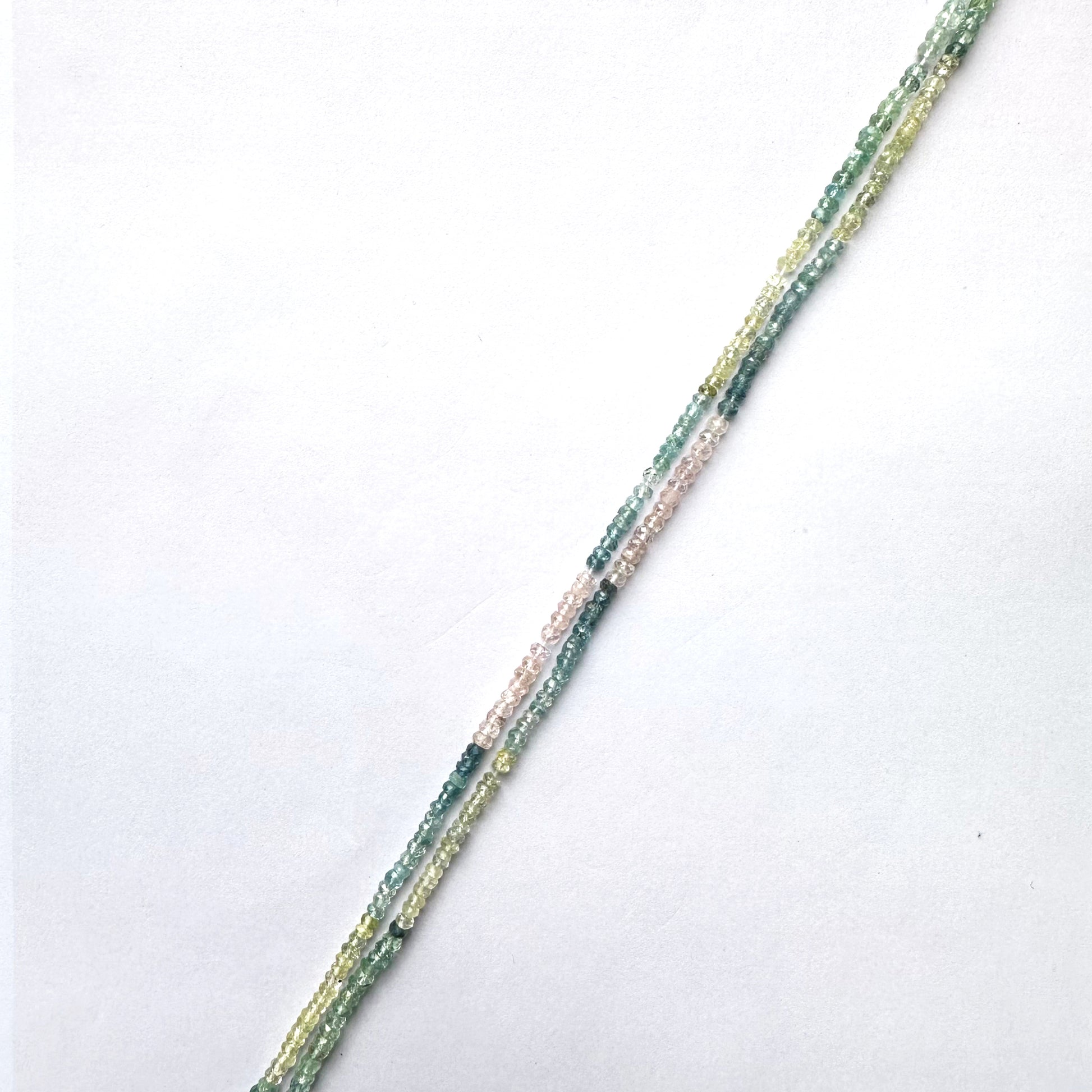 Faceted Multi Aquamarine rondelle beads with blue gradient tones arranged on a 32cm strand.