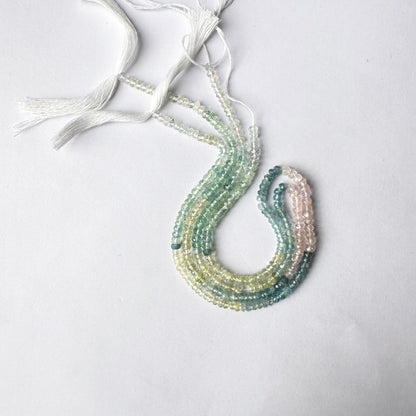 Light-catching Multi Aquamarine rondelles displayed on a natural stone surface