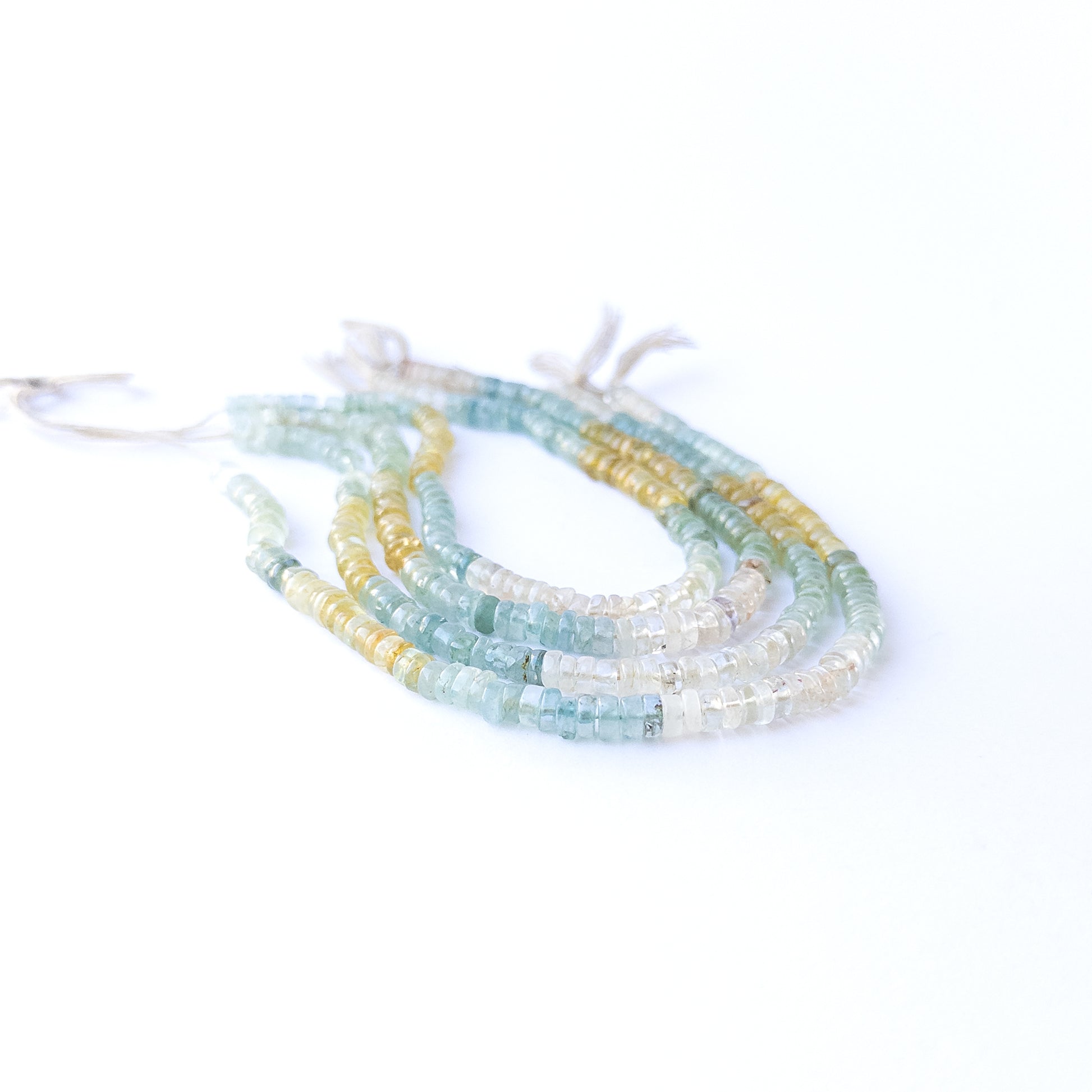 Genuine Multi Aquamarine smooth wheel stone beads showcasing their polished finish and ocean‑tone colours.