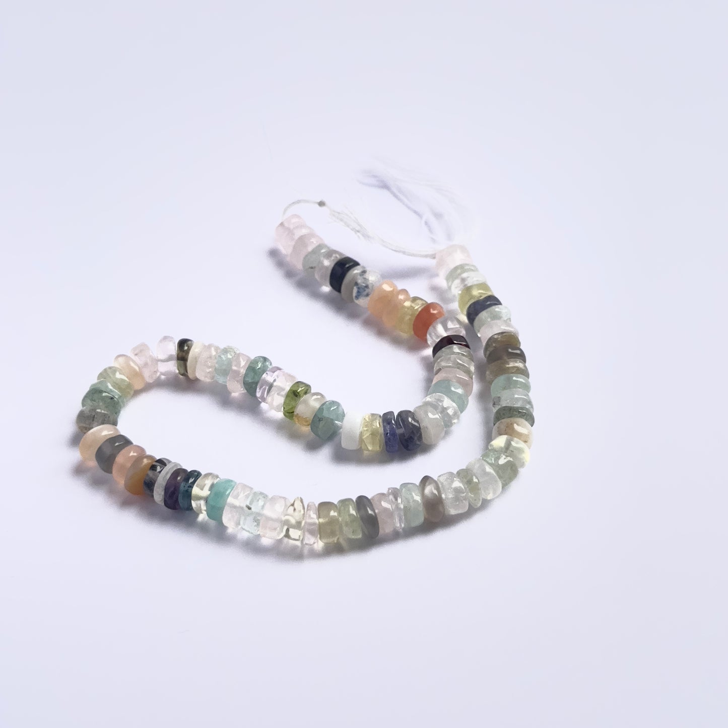 Stone beads in a strand of Multi Disco, highlighting their smooth wheels and 5.8–6mm size.