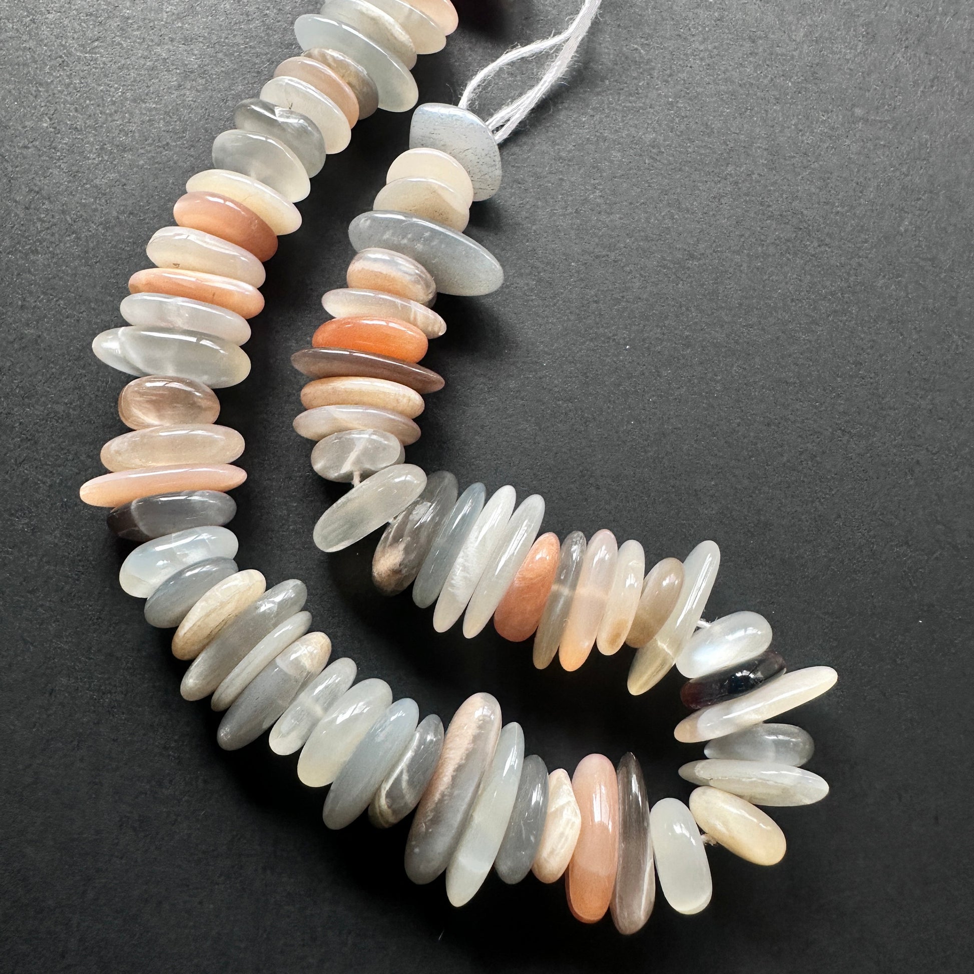 Close-up of Multi Moonstone beads showcasing their natural colour variation and smooth cut.