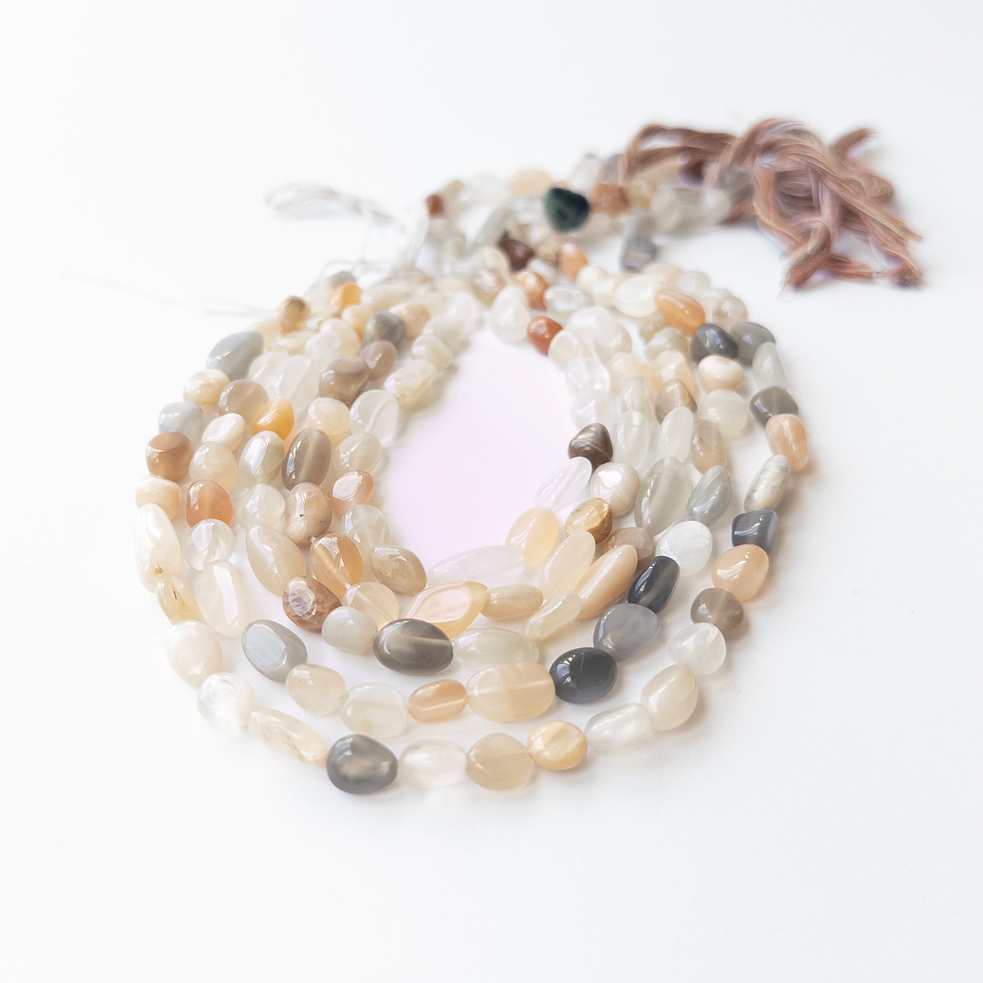 Authentic Moonstone tumble beads showing mixed hues and polished shine for artisan gemstone beadwork.