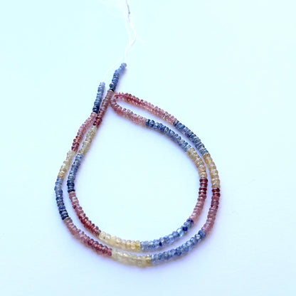 Close‑up of mixed ruby, yellow sapphire and blue sapphire 2.8–3.2mm faceted rondelle beads highlighting precise facets and bright hue