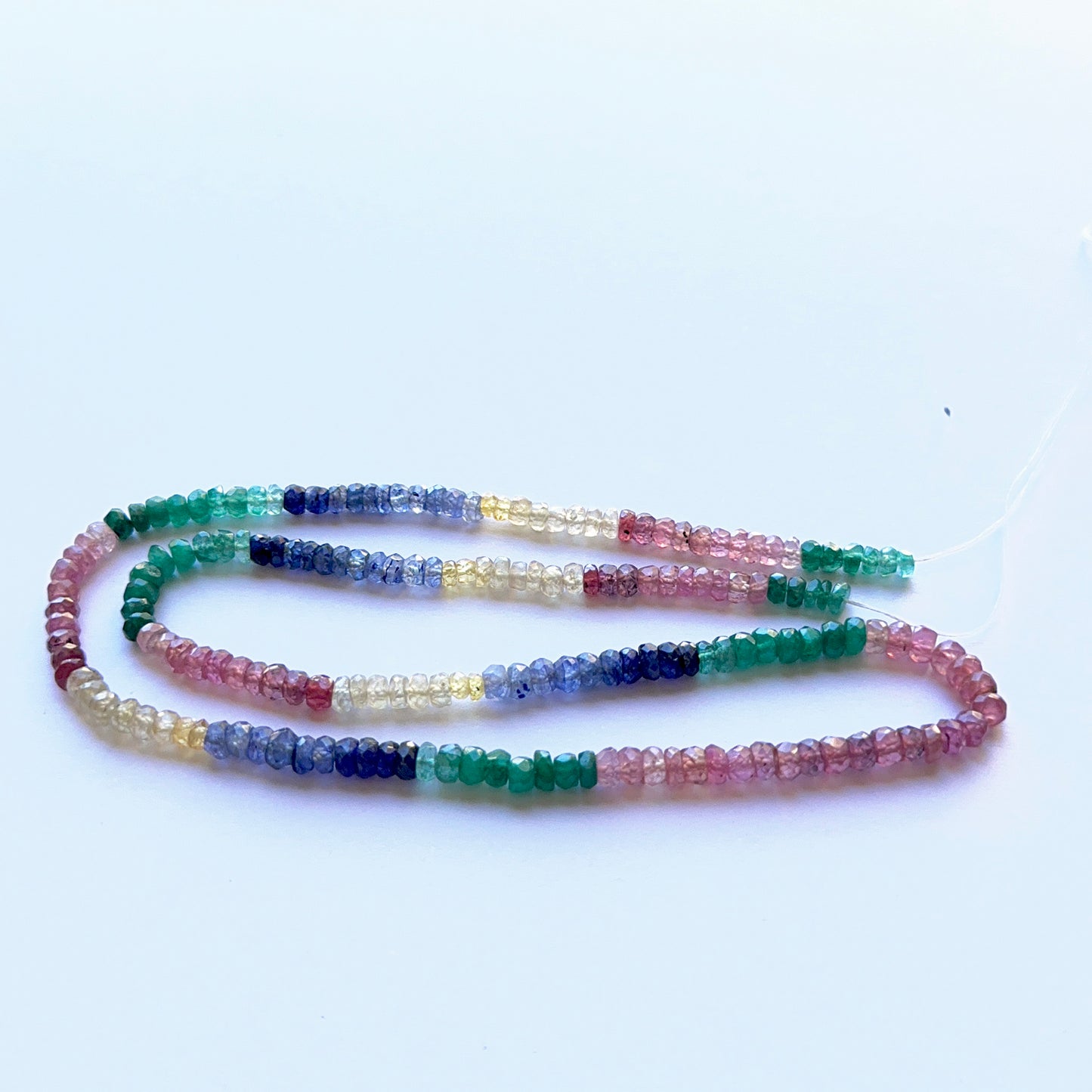 Multi‑precious faceted rondelle strand with ruby, yellow sapphire, blue sapphire and emerald 3.3–4mm, 39cm, 56 carats.
