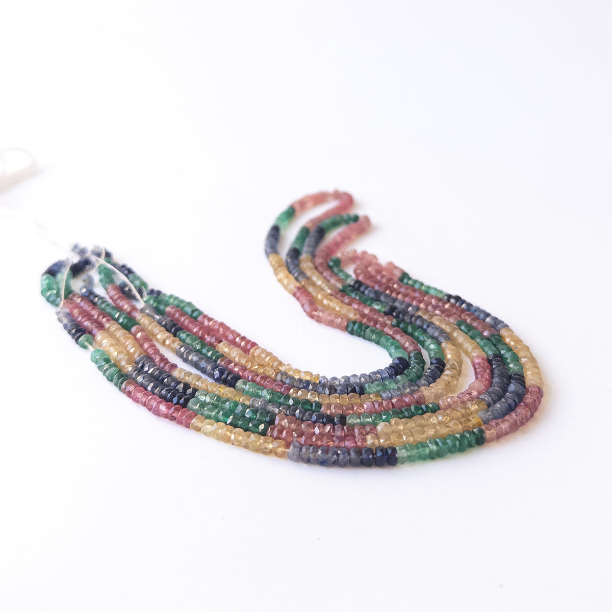 Close‑up of Multi Precious faceted rondelle beads revealing clarity, shine and fine craftsmanship.