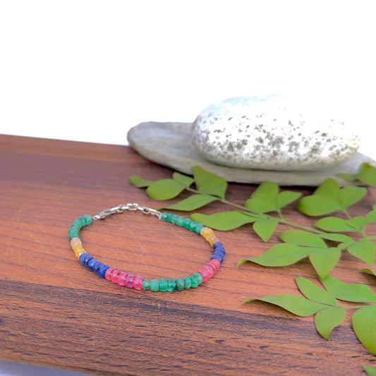 Faceted rondelle bracelet featuring ruby, emerald, blue and yellow sapphire beads.