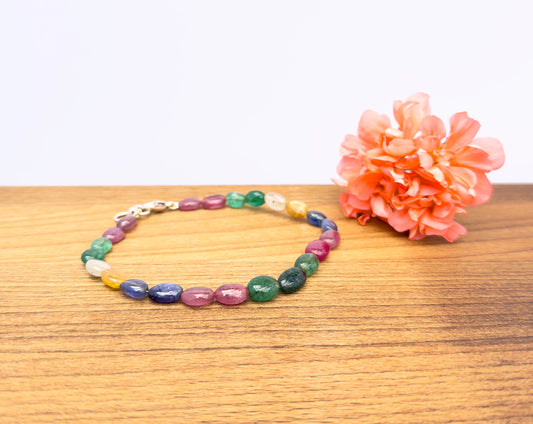 Smooth oval gemstone bracelet featuring ruby, emerald, blue and yellow sapphire beads.