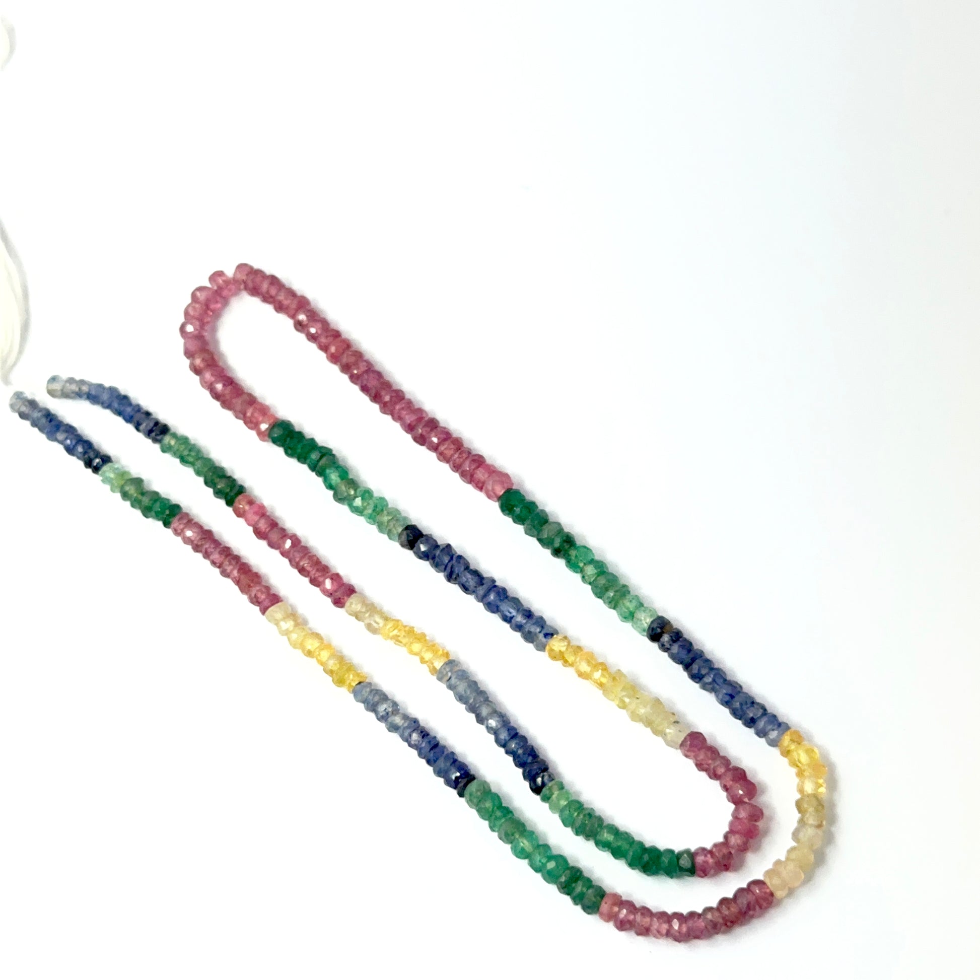 Multi precious faceted rondelles aligned on a strand, highlighting clarity, colour mix and quality stone beads.