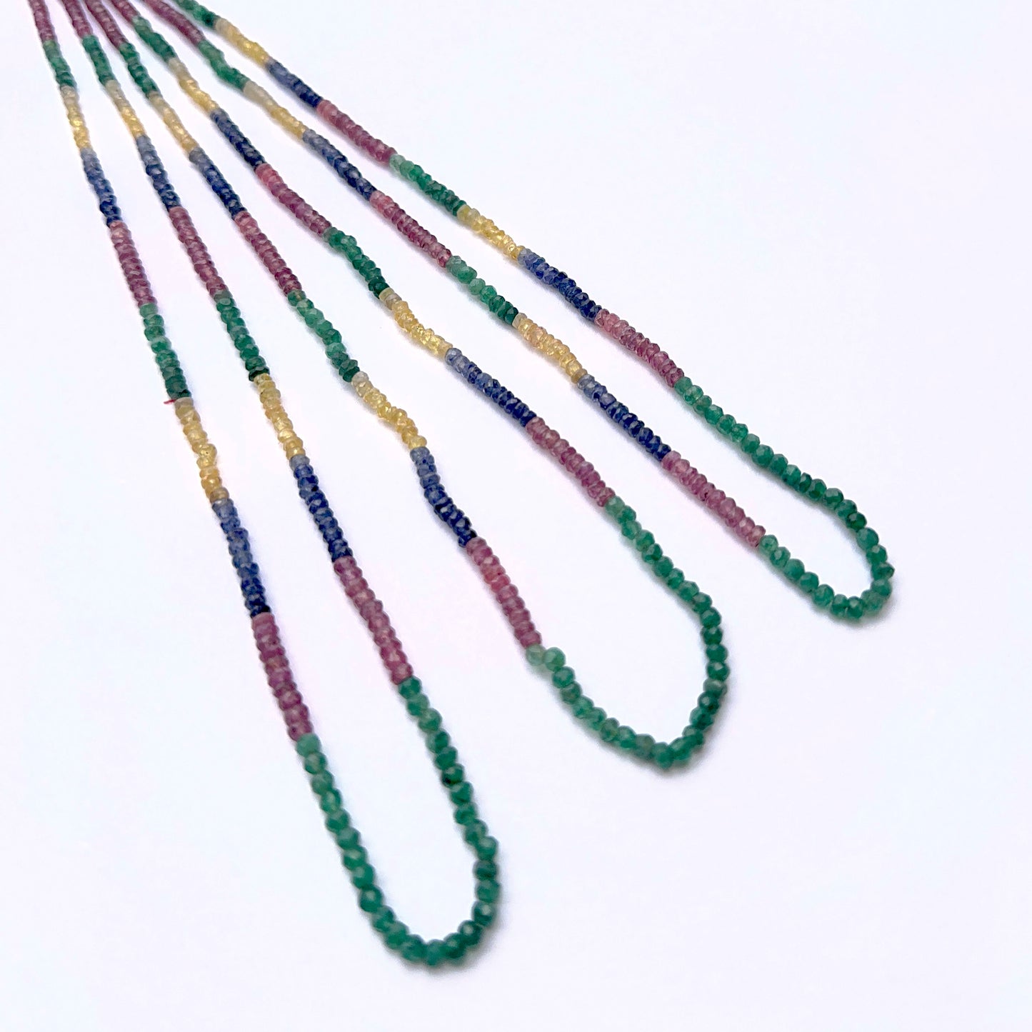 Multi precious gemstone strand with faceted beads arranged in a vibrant layout.