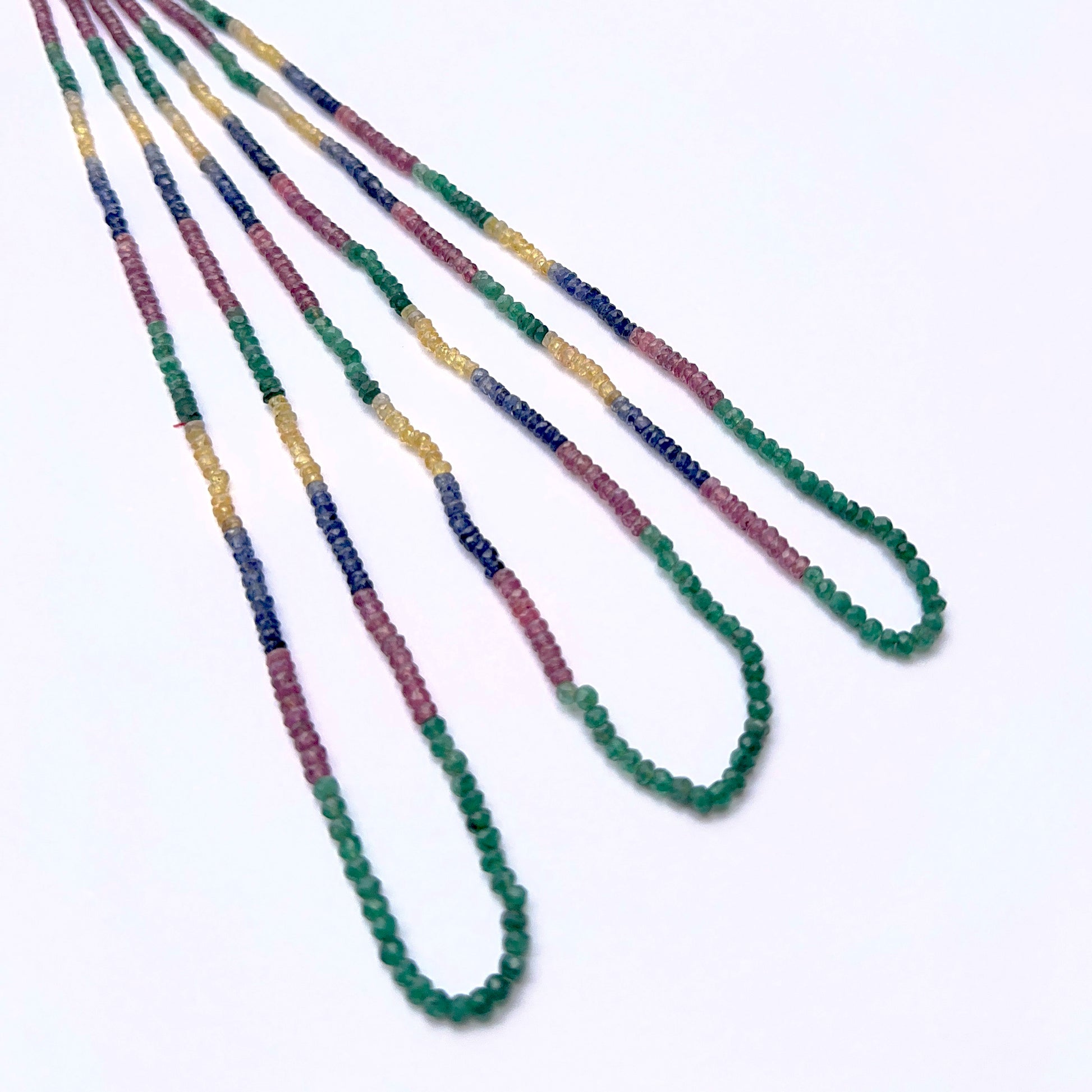 Multi precious gemstone strand with faceted beads arranged in a vibrant layout.