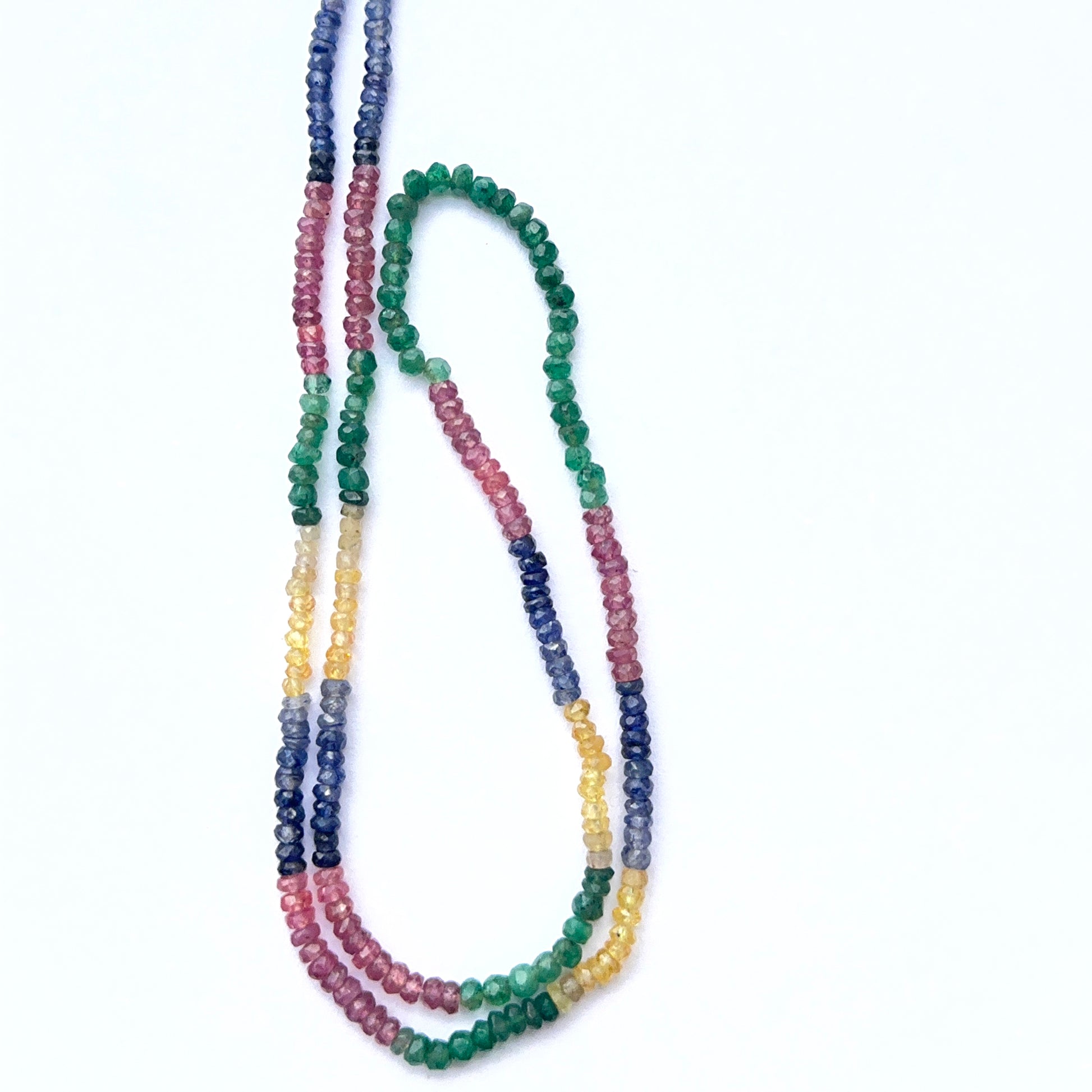Close‑up of faceted multi gemstone rondelle beads arranged as a strand.