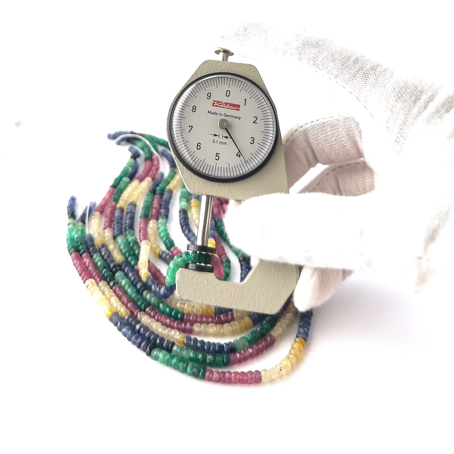 A dial gauge measures the Multi Precious Gemstone faceted rondelle 3.5–4mm gemstone.