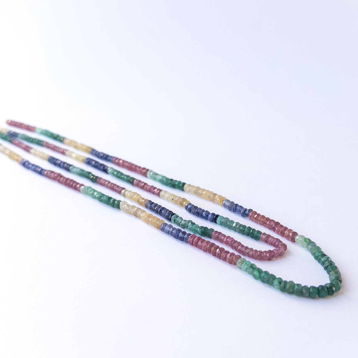 Close‑up of Multi Precious faceted rondelle beads revealing clarity, shine and fine craftsmanship.