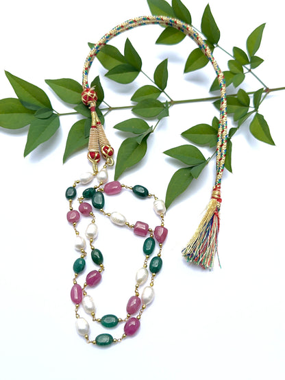 Ruby, emerald and pearl necklace with smooth tumble beads arranged in a balanced layout.