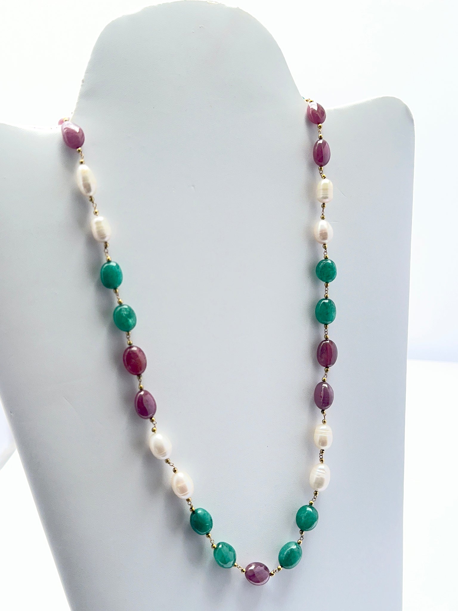 Ruby, emerald and pearl necklace with smooth and textured beads showing rich colour contrast.