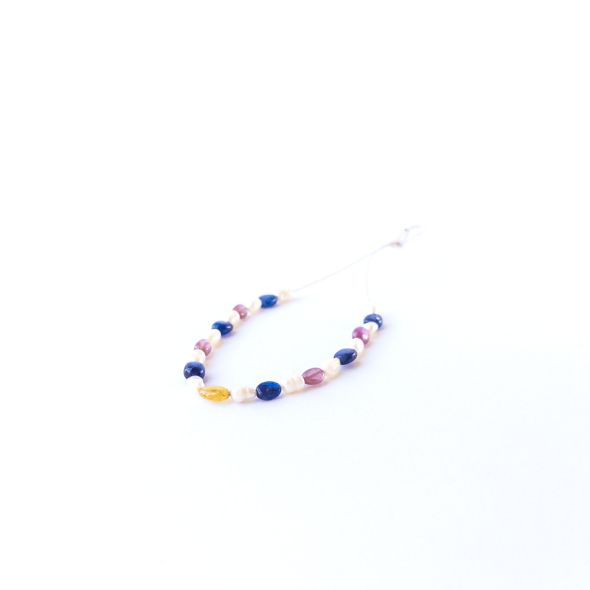 Genuine multi precious gemstone beads and freshwater pearls in smooth oval cut arranged in a 23‑piece set.