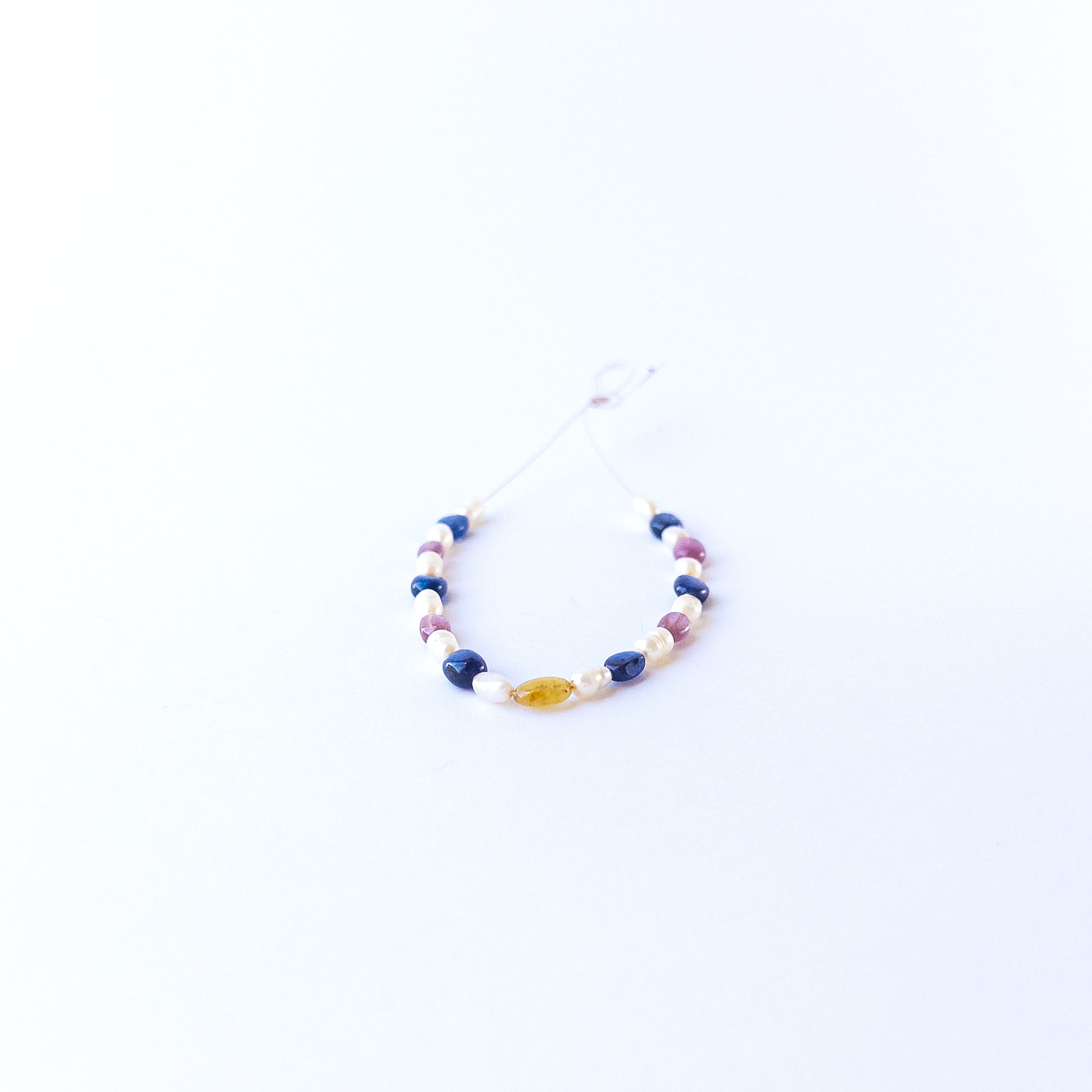 Multi precious oval beads and pearls showcasing polished surfaces and elegant colour contrast.