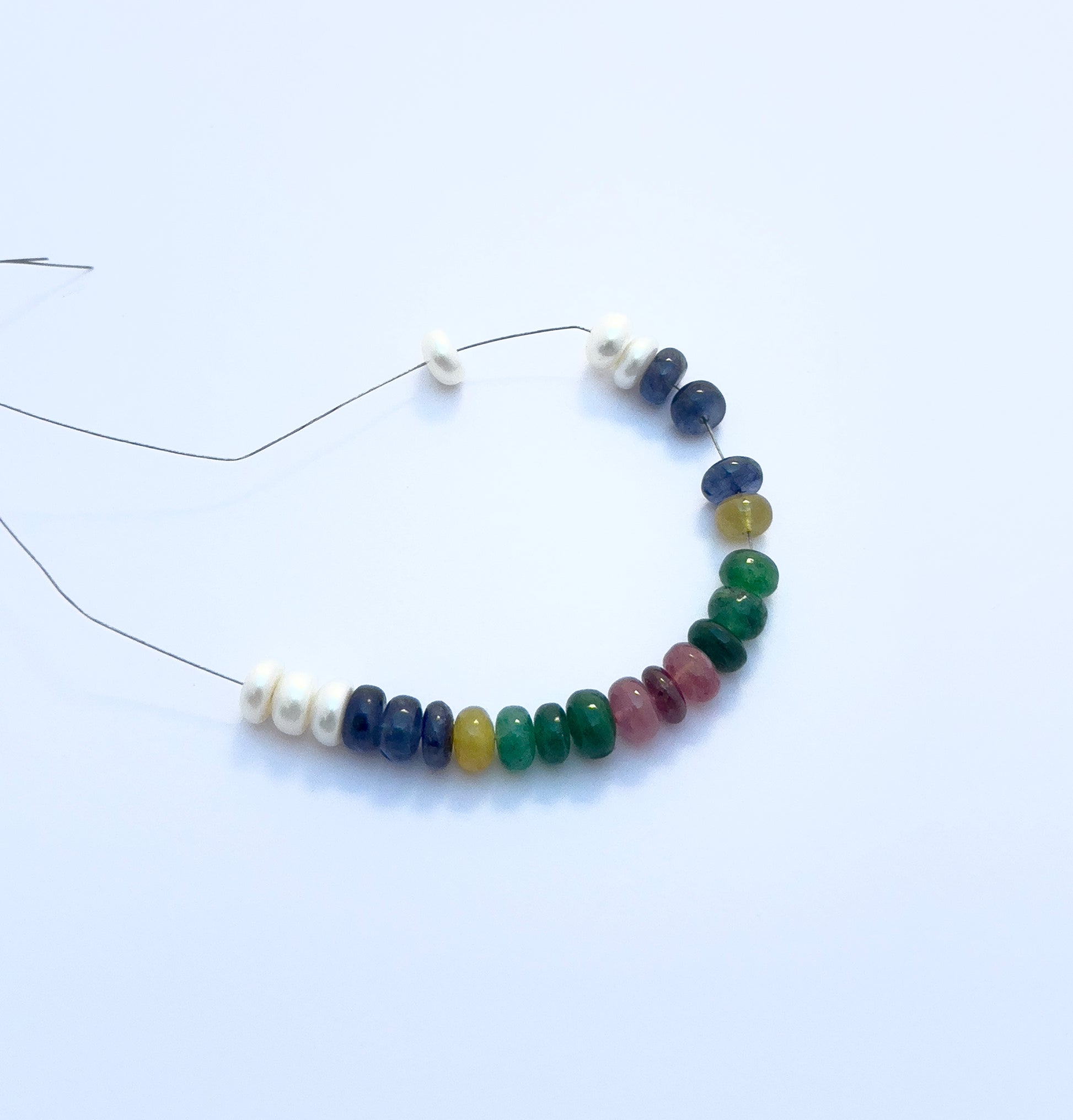 Detailed view of multi-precious bracelet with ruby, emerald, sapphire, and pearl beads totalling 35 carats.