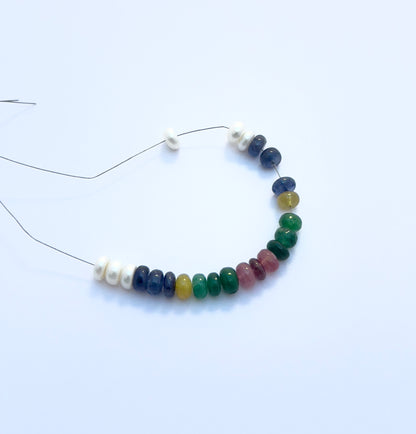 Detailed view of multi-precious bracelet with ruby, emerald, sapphire, and pearl beads totalling 35 carats.