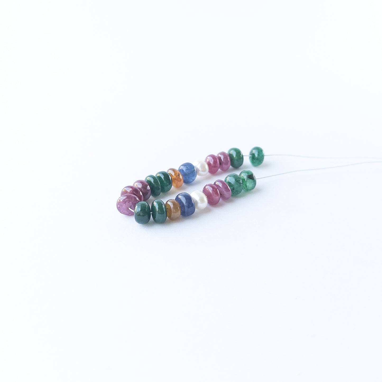Genuine stone beads in mixed precious gemstones and pearls arranged neatly for jewellery design inspiration.