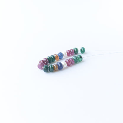 Genuine stone beads in mixed precious gemstones and pearls arranged neatly for jewellery design inspiration.