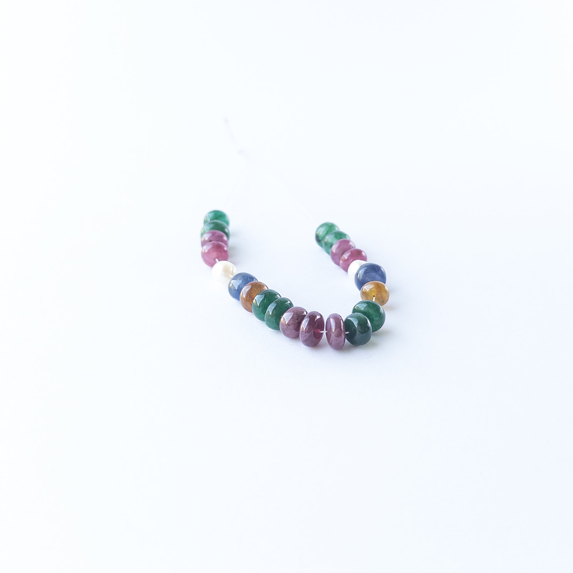 Multi precious gemstone beads and pearls showcasing polished surfaces and refined craftsmanship.