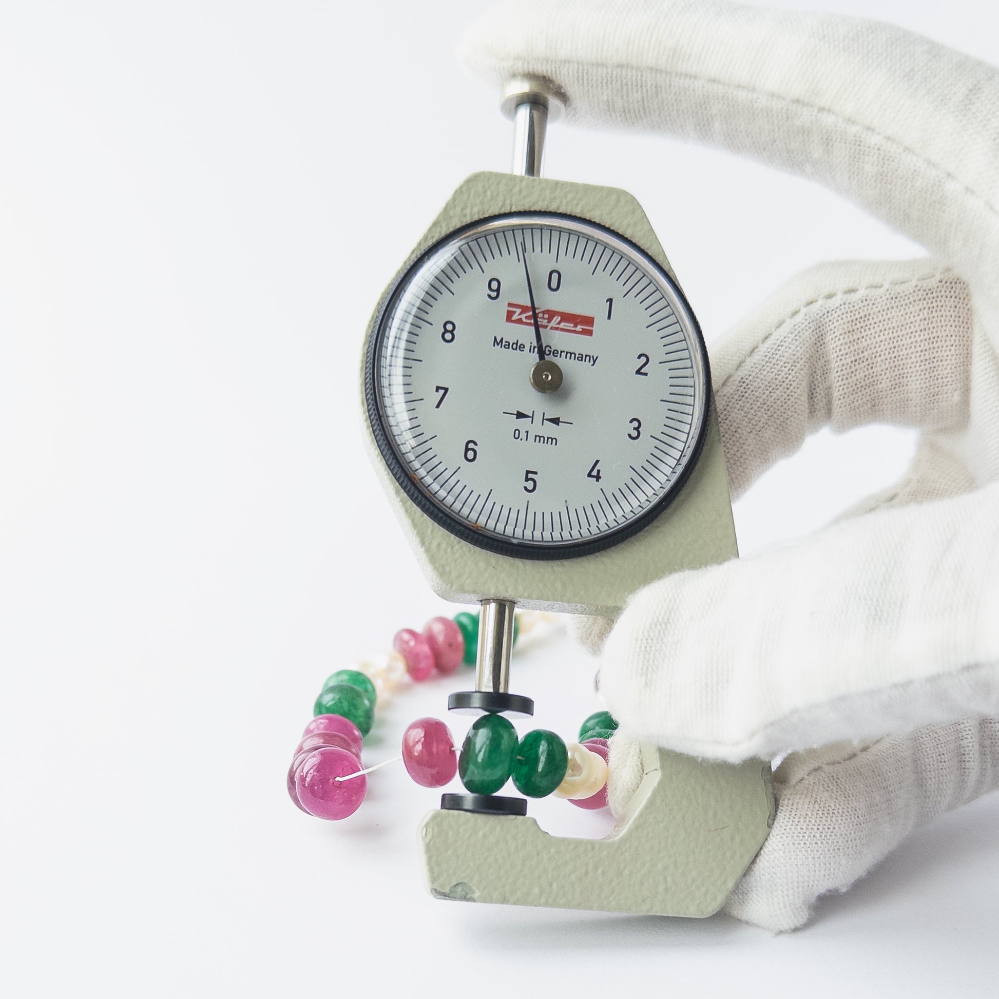 A dial gauge measures the multi precious smooth rondelle 8–8.7mm gemstone.