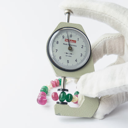 A dial gauge measures the multi precious smooth rondelle 8–8.7mm gemstone.