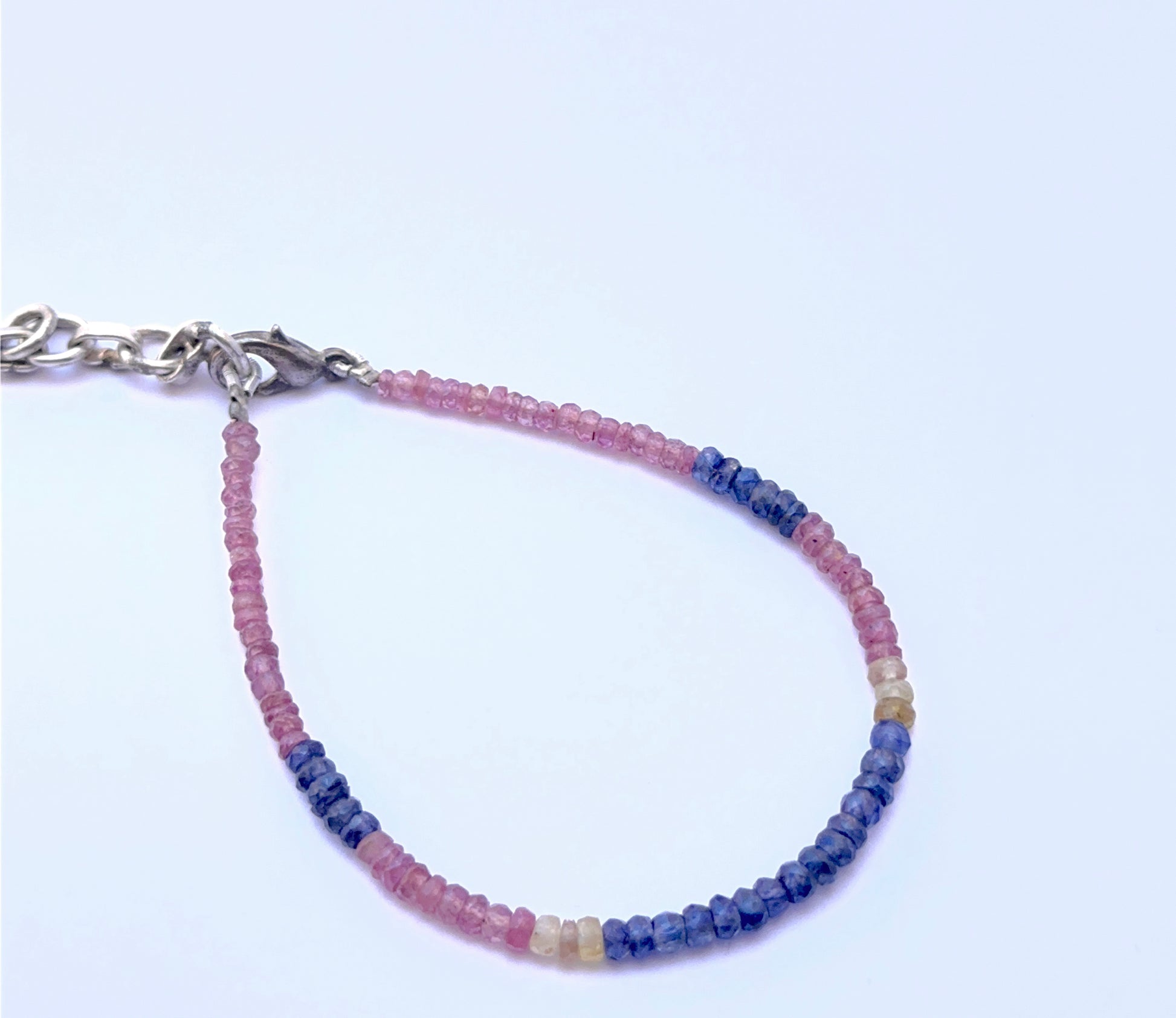 Gemstone bracelet with faceted beads arranged in a smooth design.
