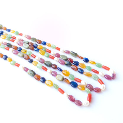 Close‑up of Navratan oval beads showing their shine, clarity and rich traditional gemstone variety.