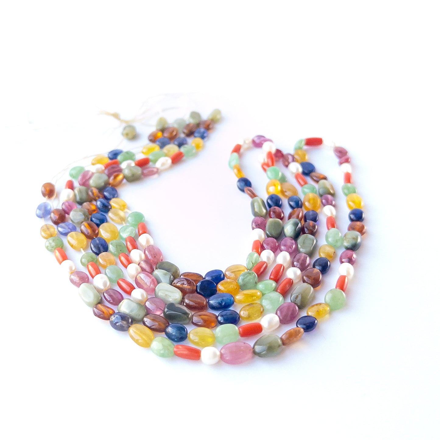 Genuine Navratan stone beads showcasing ruby, sapphire, emerald and more in polished oval cuts.