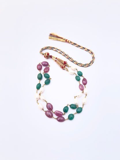 Detailed view of emerald and ruby beads alongside lustrous pearls, polished oval cut arrangement.