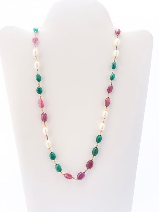Necklace combining freshwater pearls, emeralds, and rubies in smooth oval beads, radiant gemstone mix.