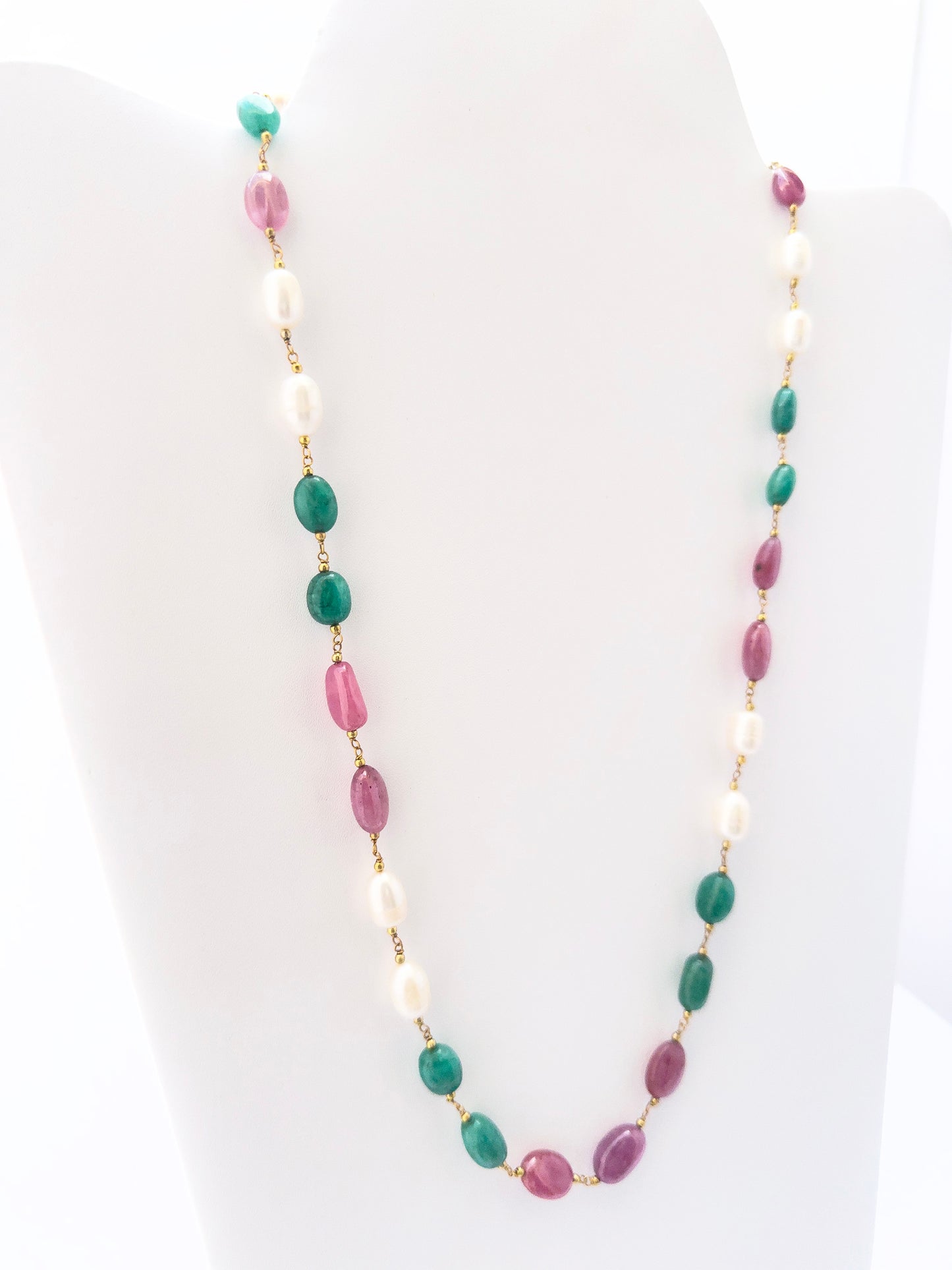 Multi precious strand necklace showcasing vibrant green emeralds, deep red rubies, and glowing pearls.