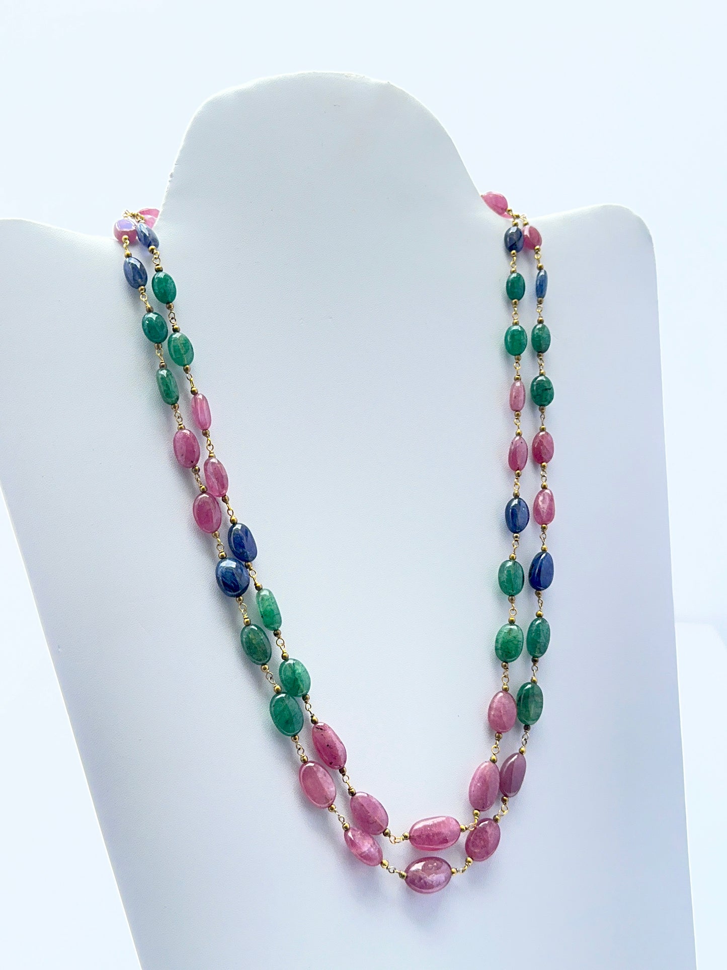Emerald, ruby and sapphire necklace with smooth oval beads showing rich colour.