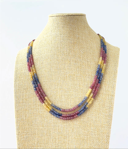 Three‑strand multi‑precious necklace featuring faceted rondelle ruby, blue sapphire, and yellow sapphire beads sized 4–4.5mm.
