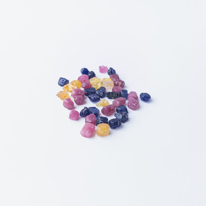 Mixed Ruby, Blue Sapphire and Yellow Sapphire rough stones arranged together showing vivid colour contrast.