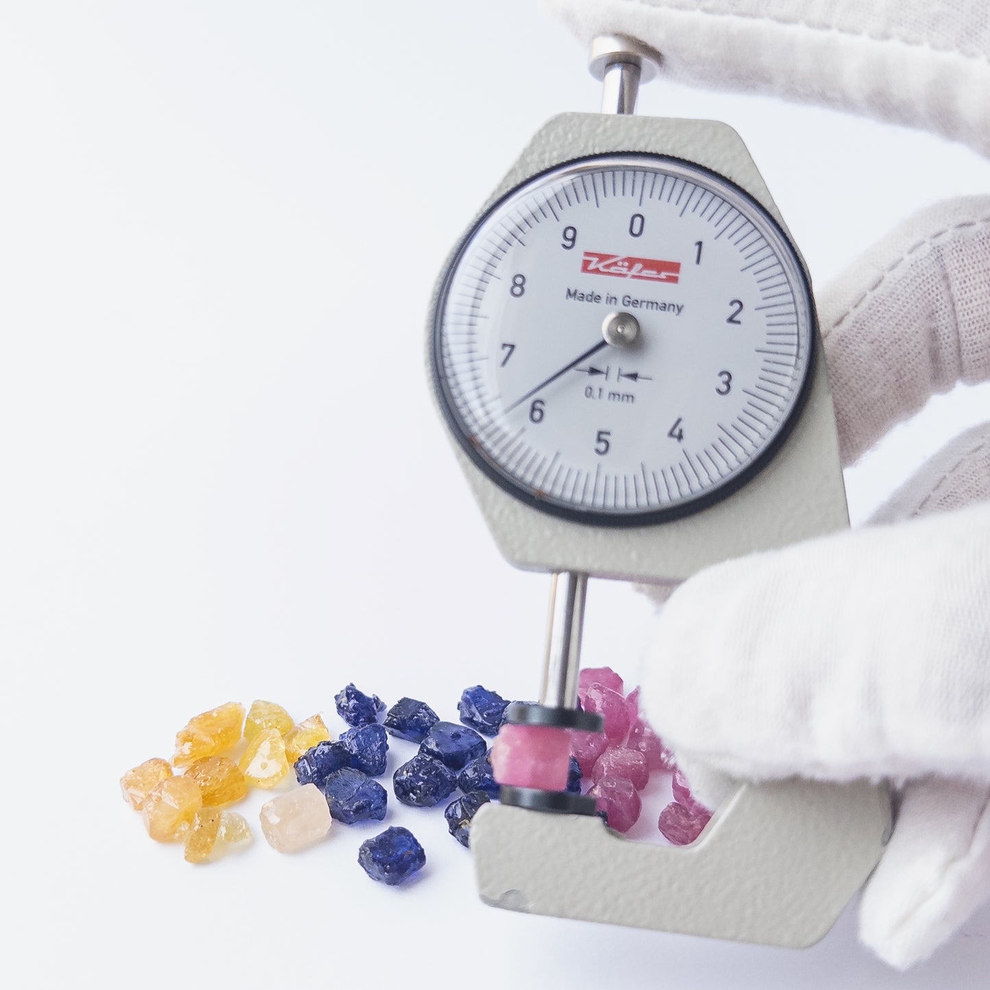 A dial gauge measures the Ruby, Blue Sapphire and Yellow Sapphire rough 6–7mm gemstone.