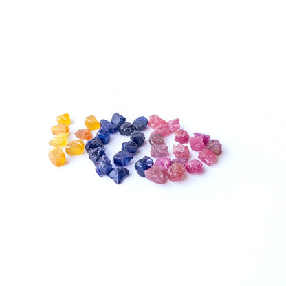 Mixed Ruby, Blue Sapphire and Yellow Sapphire rough stones arranged together showing natural colour contrast.