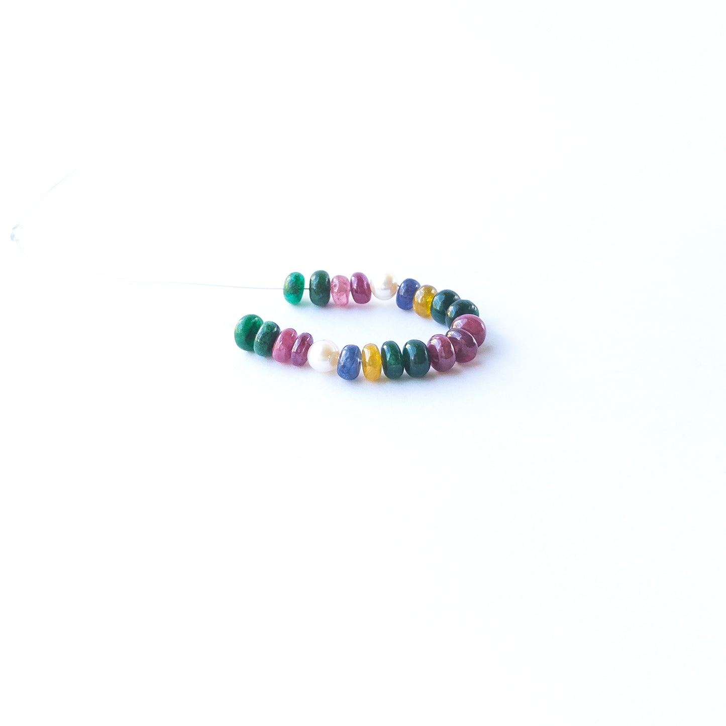 Close‑up of genuine Ruby, Emerald, Sapphire and Pearl rondelle beads showing polished shine and natural gemstone quality.