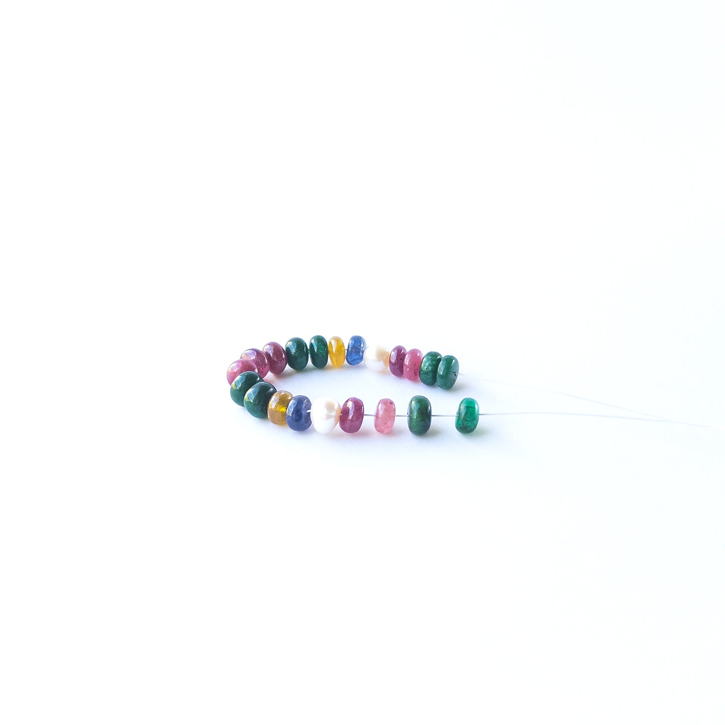 Smooth rondelle Ruby, Emerald, Sapphire and Pearl beads displaying natural colour variation and premium craftsmanship.