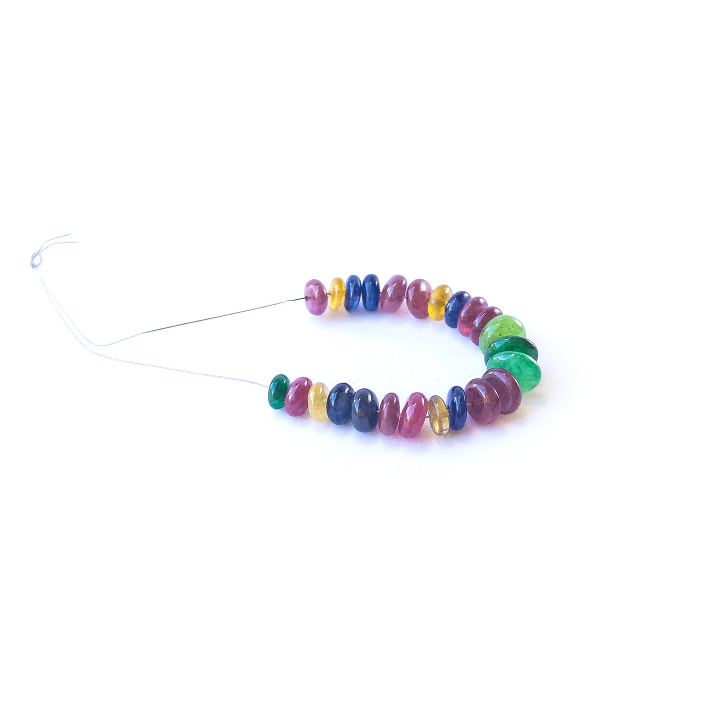 Genuine Ruby, Emerald and Sapphire gemstone beads arranged in a strand for artisan jewellery creators.