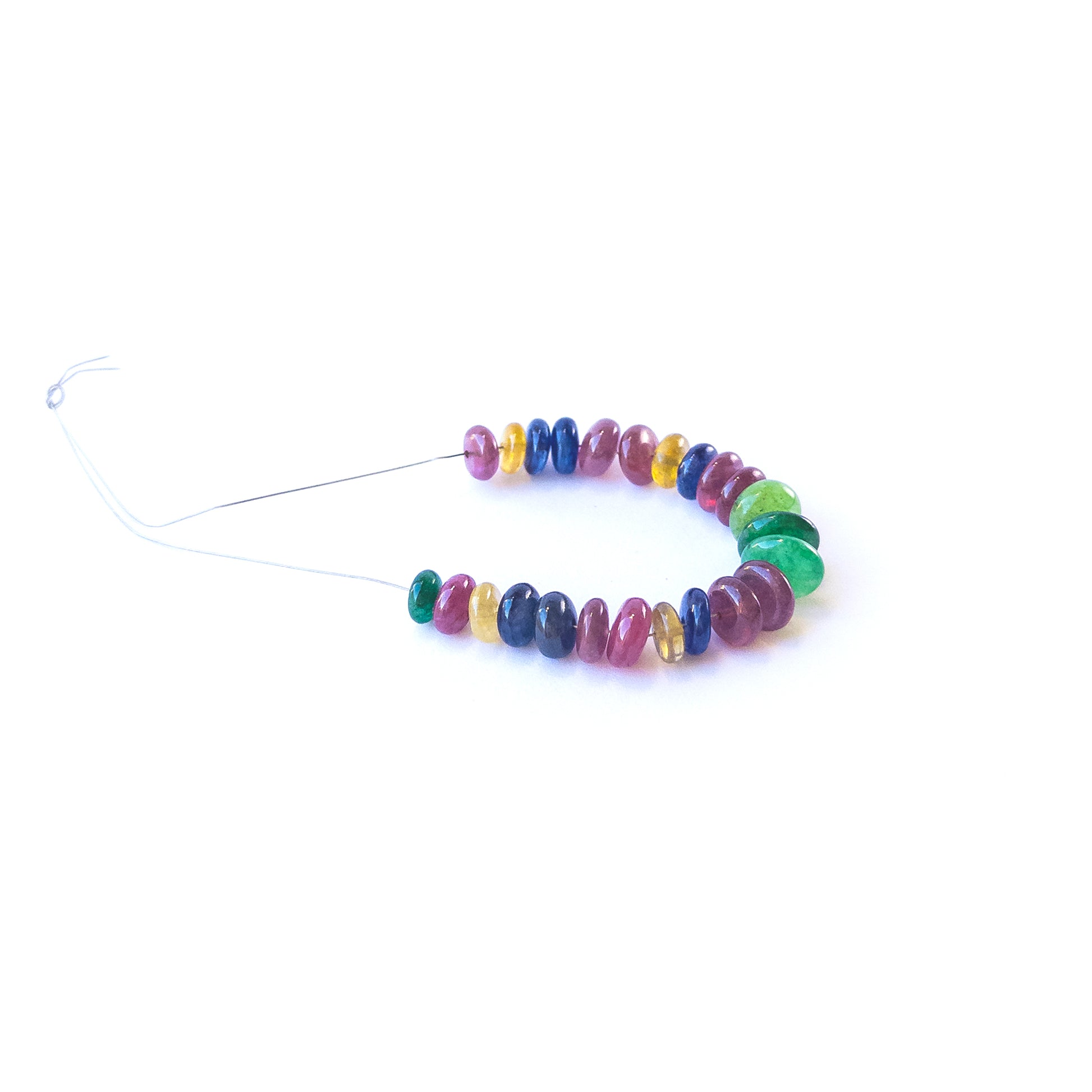 Genuine Ruby, Emerald and Sapphire gemstone beads arranged in a strand for artisan jewellery creators.