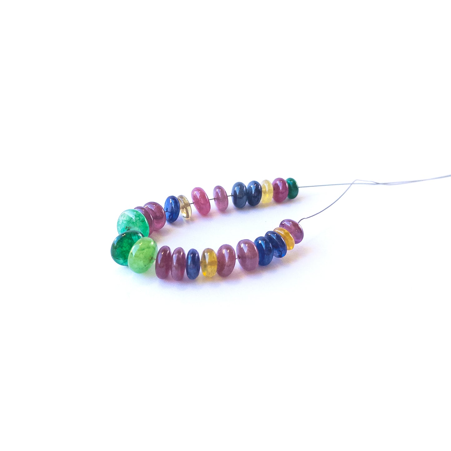 Smooth rondelle Ruby, Emerald and Sapphire beads displaying natural colour variation and high‑quality craftsmanship.