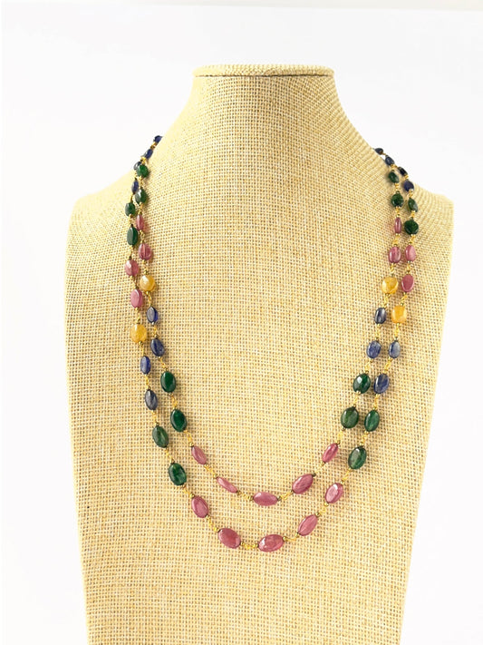 Two‑strand multi‑precious necklace featuring smooth oval ruby, sapphire, and emerald beads sized 6–7mm.
